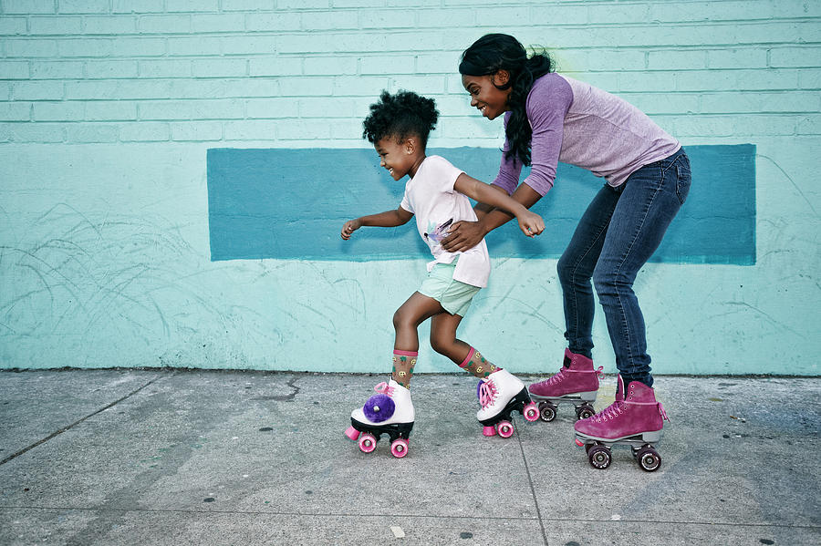 Black mother holding waist of daughter wearing roller skates Photograph by Peathegee Inc