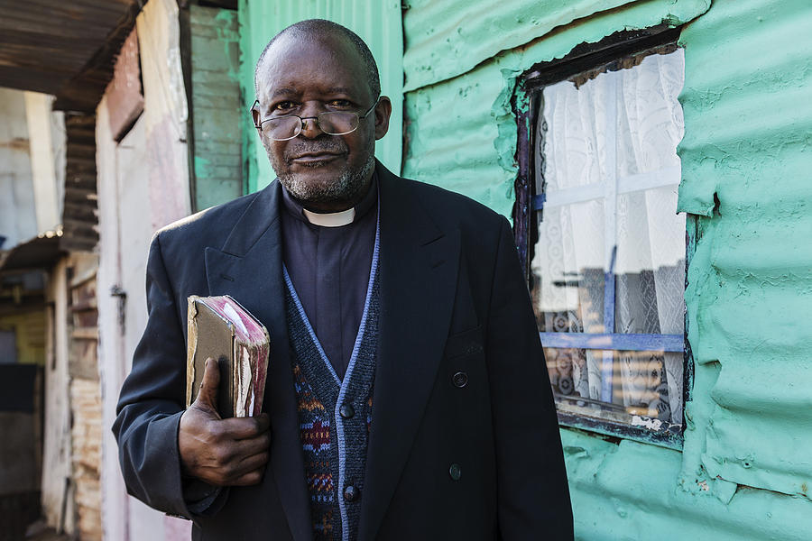 Black priest carrying bible Photograph by Pixelchrome Inc