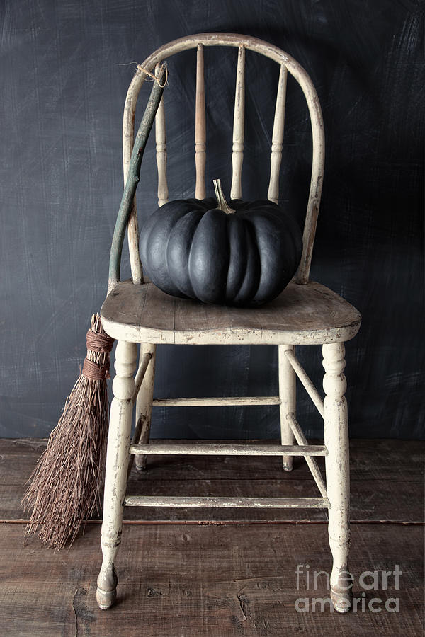 Black pumpkin on chair with old broom Photograph by Sandra Cunningham
