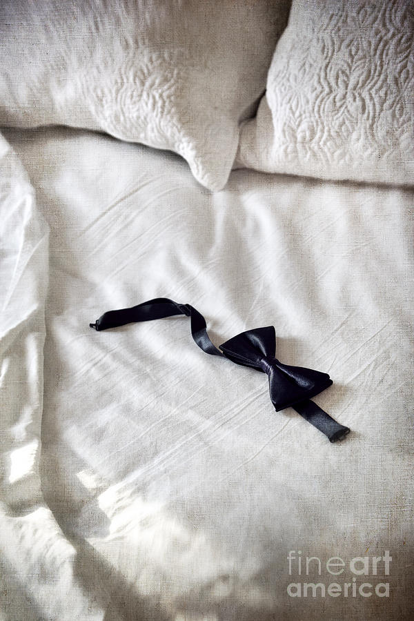 Black satin bow tie laying on unmade bed Photograph by Sandra Cunningham