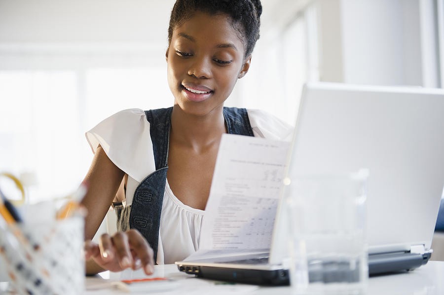 Black woman paying bills online Photograph by Blend Images - JGI/Jamie Grill