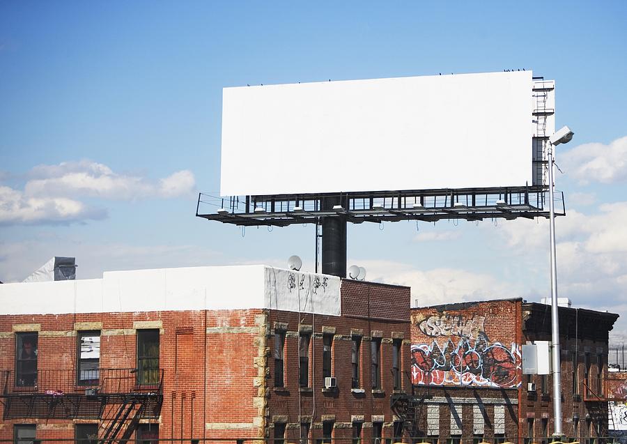 Blank billboard over urban buildings Photograph by Fotog