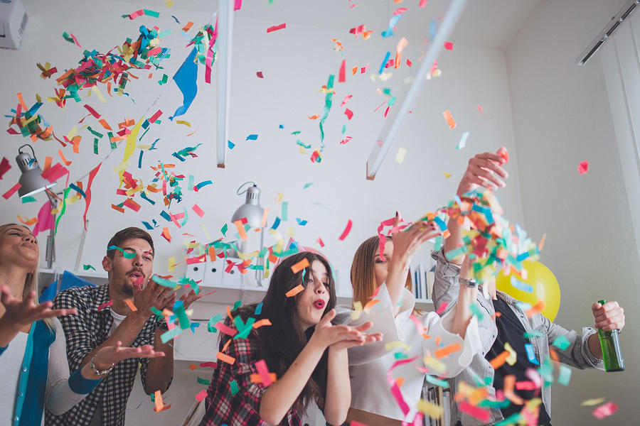 Blowing confetti on party Photograph by South_agency
