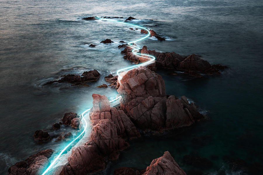 Blue light trail following footpath between the stunning coastline during sunrise. Photograph by Artur Debat
