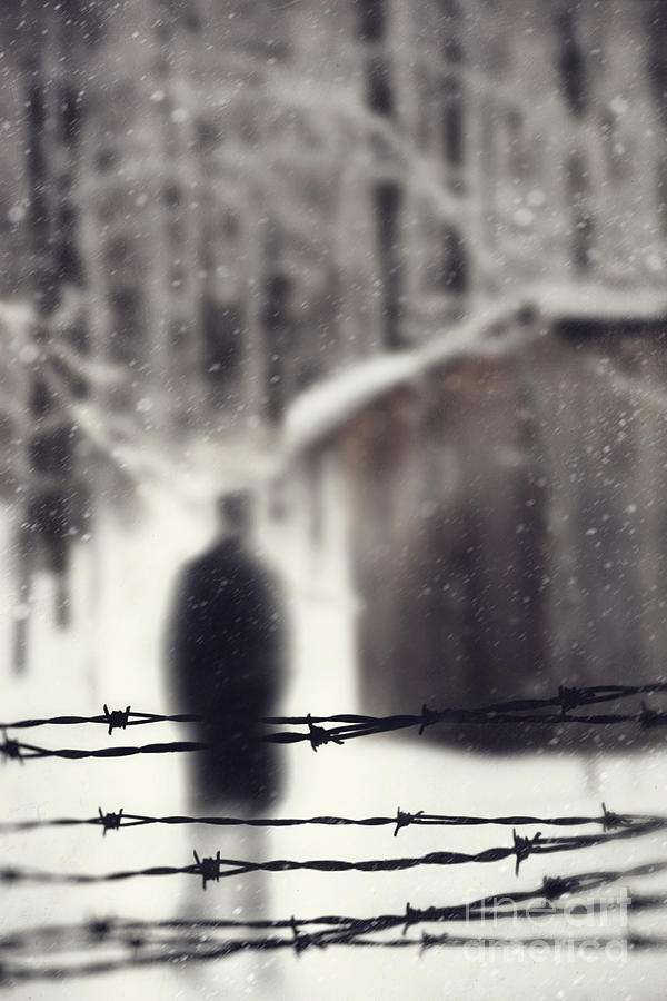Blurred figure behind barbed wire fence Photograph by Sandra Cunningham
