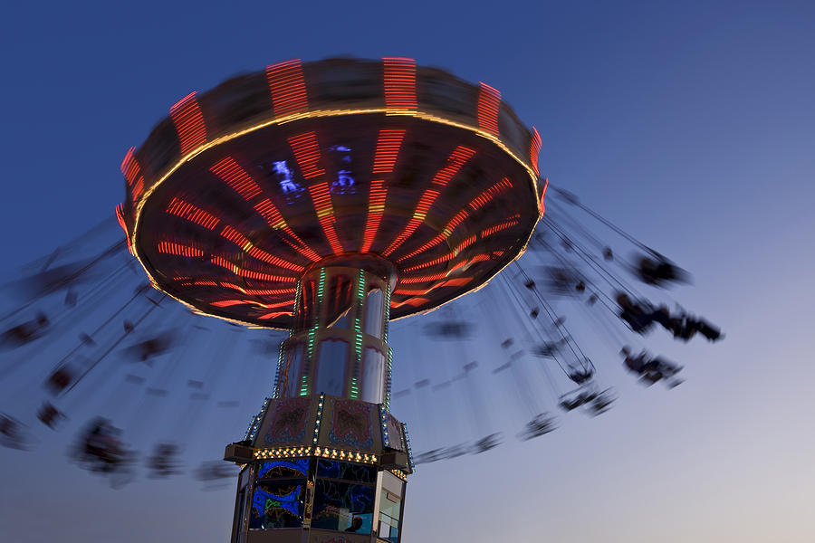 Blurred motion of merry-go-round chairoplane at night Photograph by Grafissimo