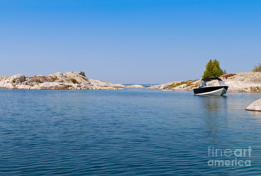 Boat on a blue lake Photograph by Les Palenik