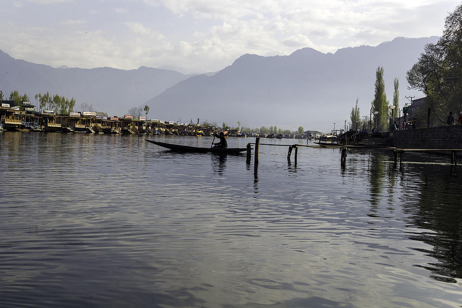 Boatman on a small wooden boat near the shore of the Dal Lake Photograph by Ashish Agarwal