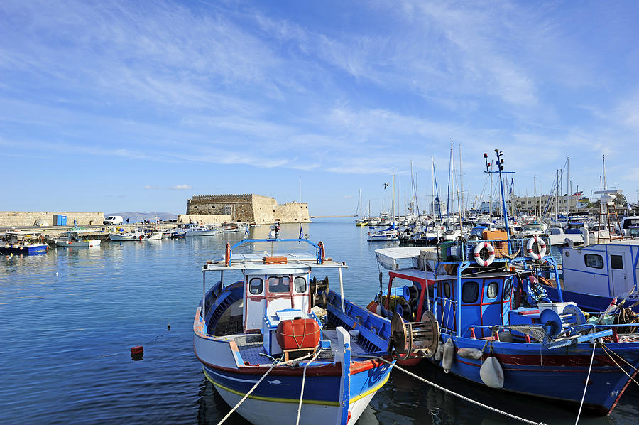 Boats docked in the blue waters of Iraklion Photograph by Majaiva