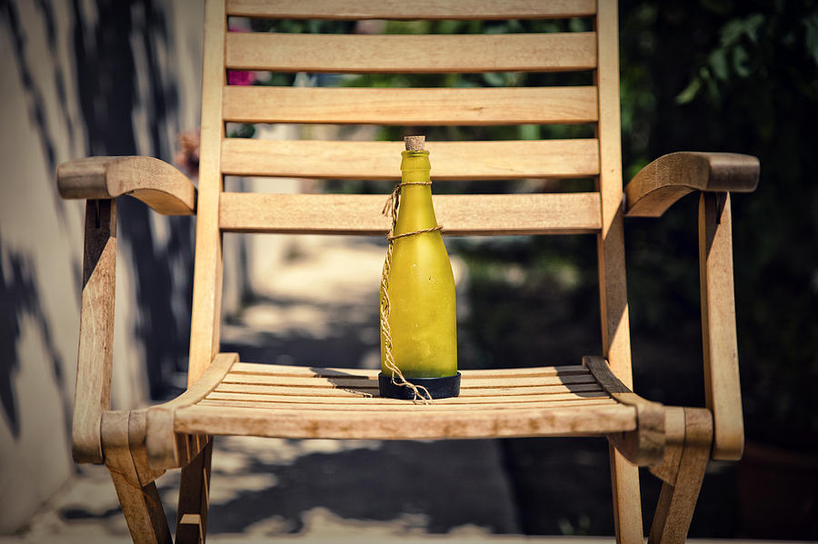 Bottle on wooden chair Photograph by Mike Santis