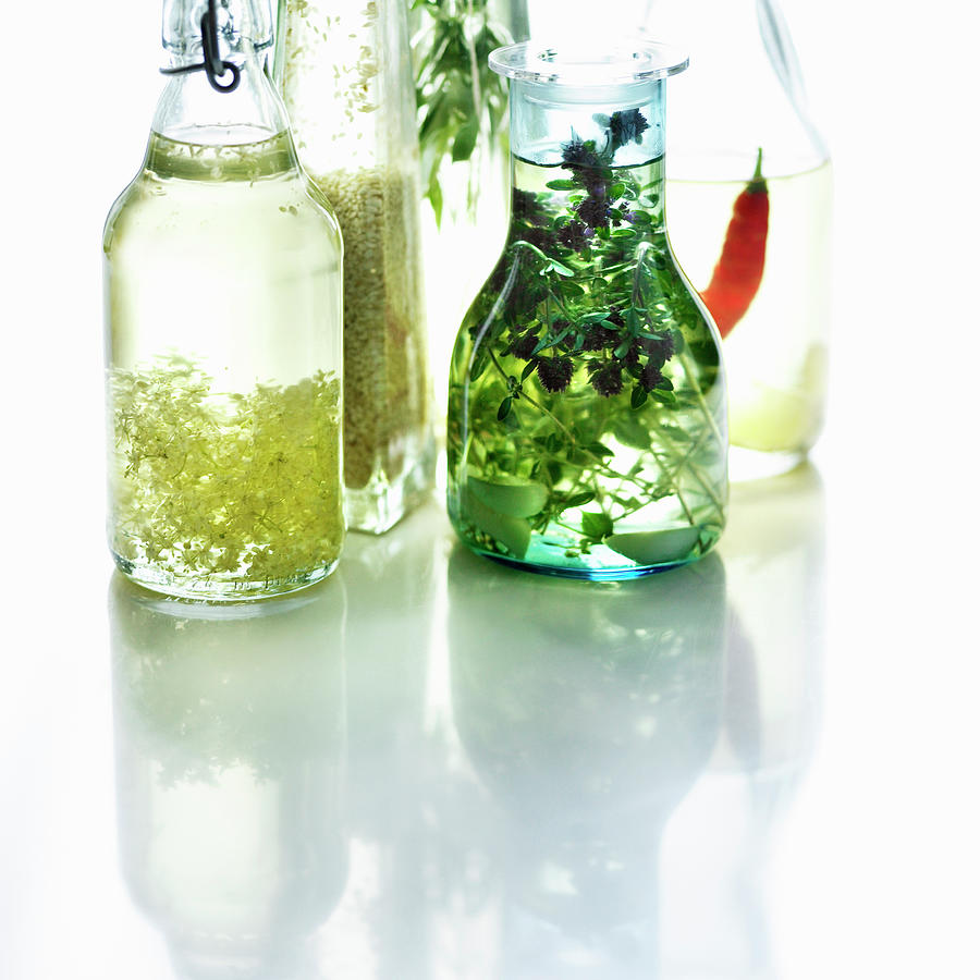 Bottles Of Herbed Olive Oil Photograph by Lisbeth Hjort