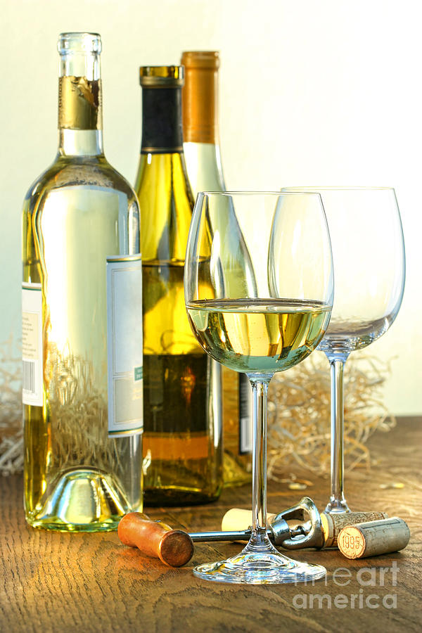 Bottles of white wine with glasses  Photograph by Sandra Cunningham