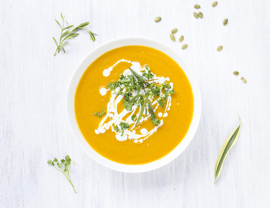 Bowl of carrot pumpkin soup with topping Photograph by Westend61