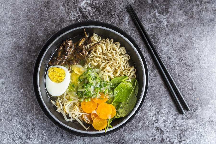 Bowl of ramen soup with spinach, carrot, boiled egg, bamboo sprouts and mushrooms Photograph by Westend61