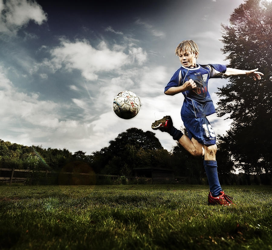 Boy (10-11) playing soccer Photograph by David Trood