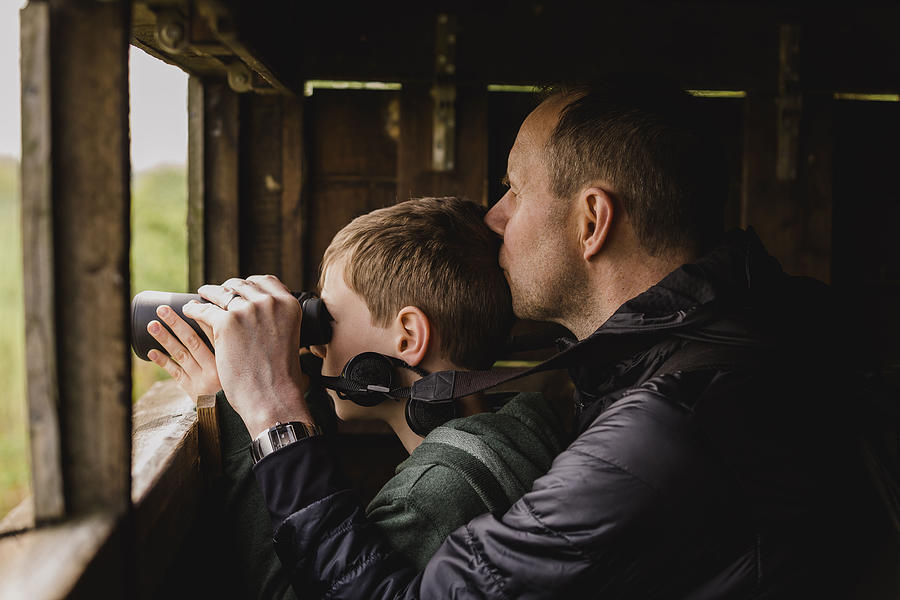 Boy and father birdwatching with binoculars Photograph by Westend61