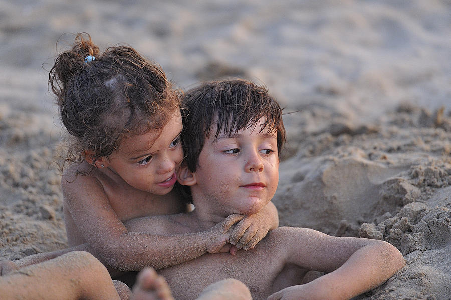 Boy and girl playing in sand, Spain Photograph by Pepepalosamigos