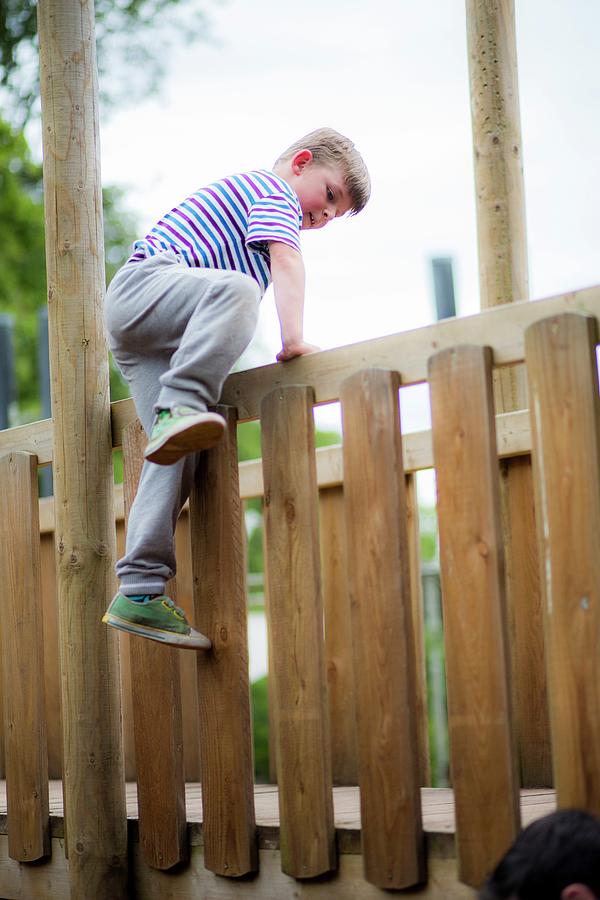 Boy Climbing Over Wooden Fence Photograph By Samuel Ashfield Fine Art