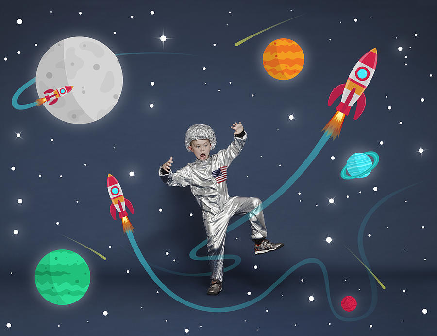Boy dressed as an astronaut. Cartoon space scene Photograph by Flashpop