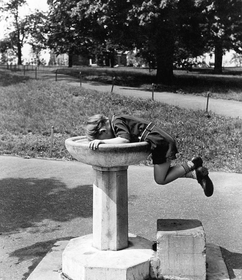 Black And White Photograph - Boy Drinking From Fountain by Underwood Archives