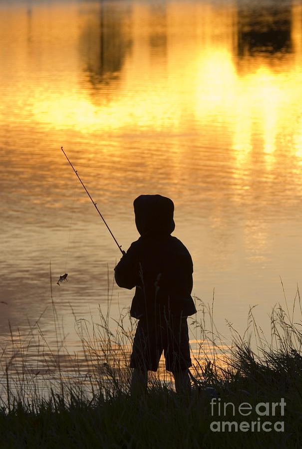Boy Fishing At Sunset Photograph