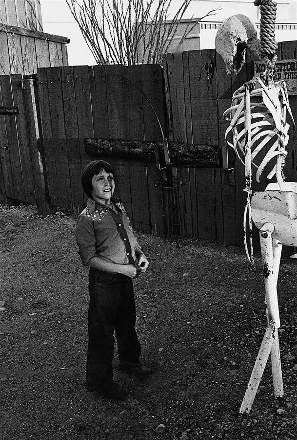 Boy hanging skeleton backlot Old Tucson Arizona 1980 Photograph by David Lee Guss