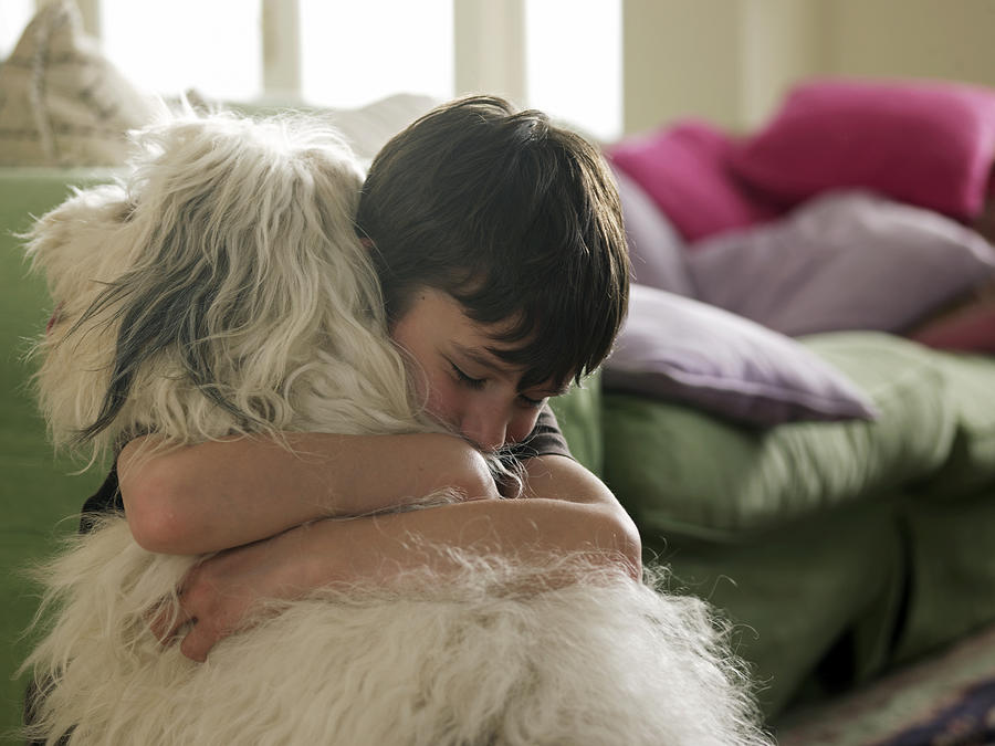 Boy hugging his dog Photograph by John Howard