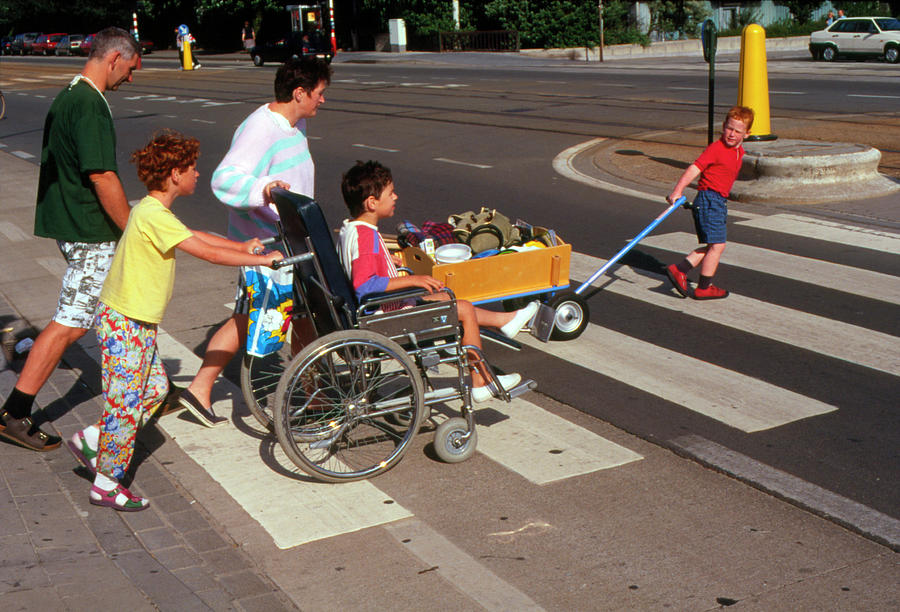 Boy In Wheelchair Crossing Road With Family Photograph by Cc Studio/science Photo Library