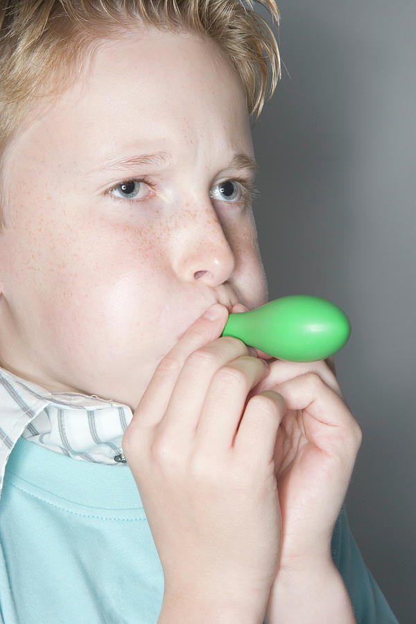 Boy Inflating A Balloon Photograph by Gustoimages/science Photo Library