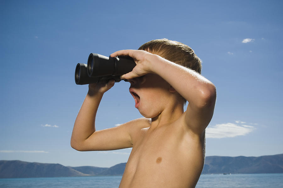 Boy looking through binoculars, Utah, United States Photograph by Erik Isakson