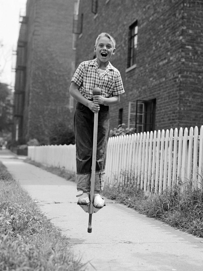 Boy On Pogo Stick, C.1960s Photograph by Debrocke/ClassicStock