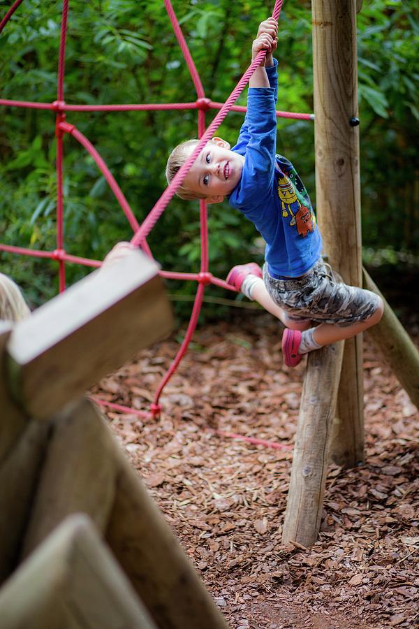 Boy Playing On Climbing Frame Photograph by Samuel Ashfield