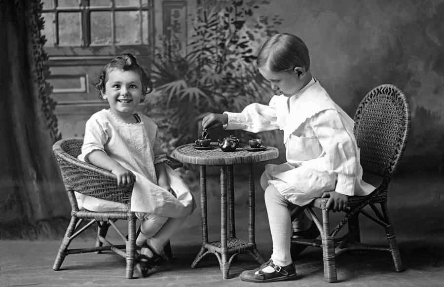 Black And White Photograph - Boy Pours Sister A Cup Of Tea by Underwood Archives