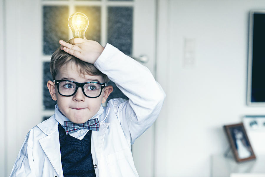 Boy puts light bulb on top head and gets idea Photograph by Mikkelwilliam