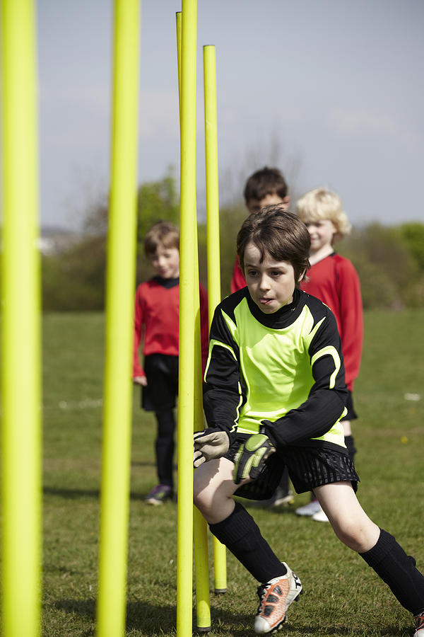 Boy running around training poles Photograph by J and J Productions