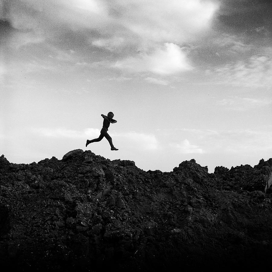 Boy Running over Dirt Pile Photograph by Donald Erickson - Fine Art America