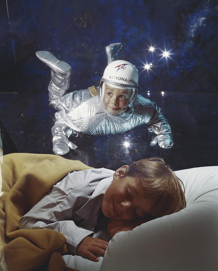 Boy sleeping on bed dreaming of astronaut Photograph by Tom Kelley Archive