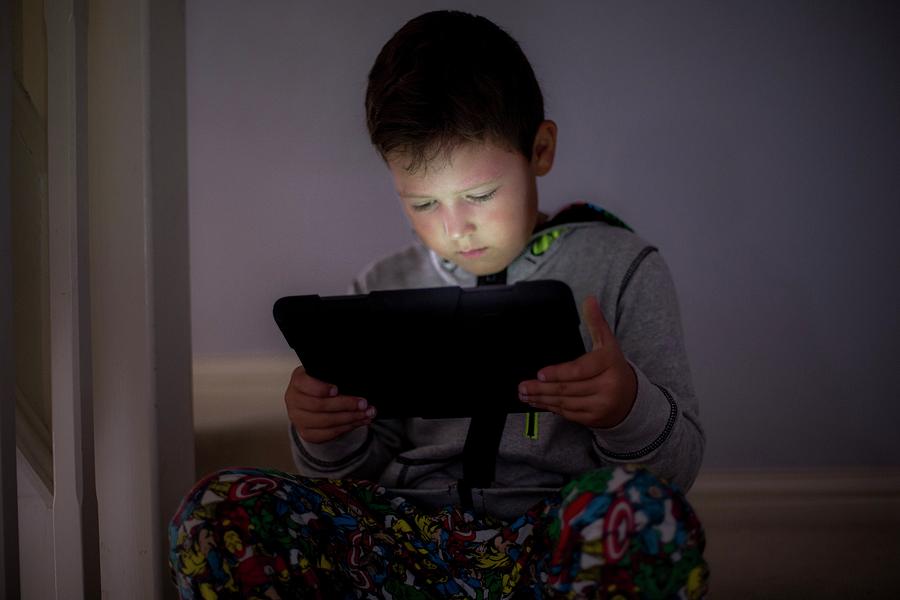 Boy Using A Digital Tablet In The Dark Photograph by Samuel Ashfield
