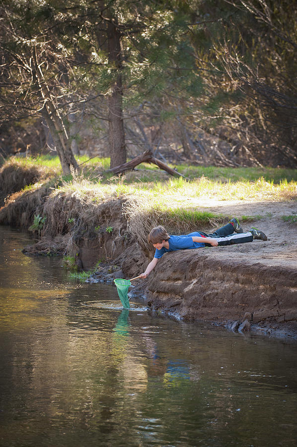 Boy With Net Playing In A Stream Photograph by Stephen Simpson