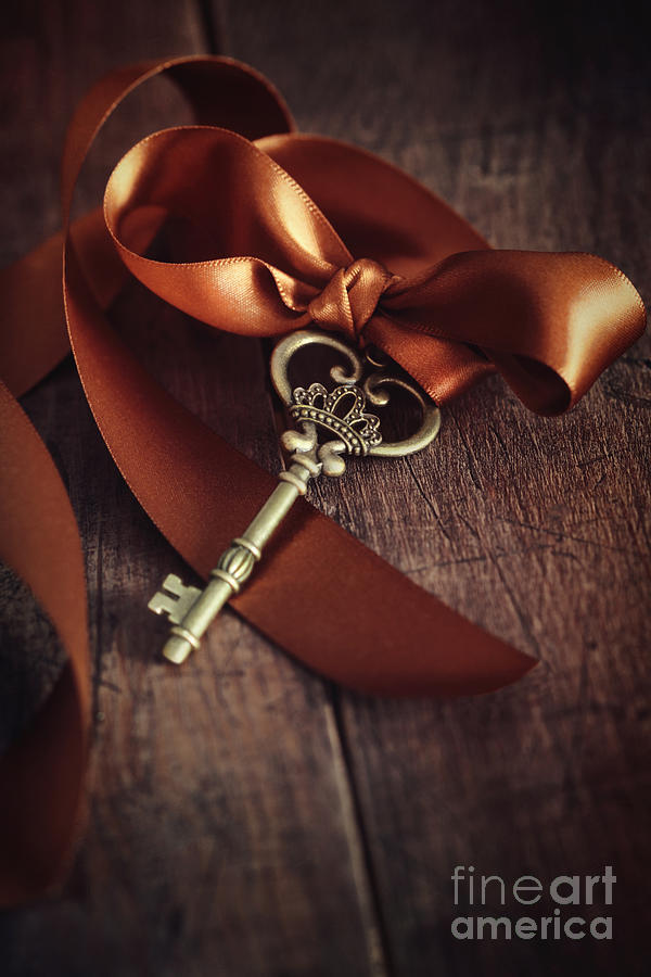Brass key with satin ribbon on wood Photograph by Sandra Cunningham