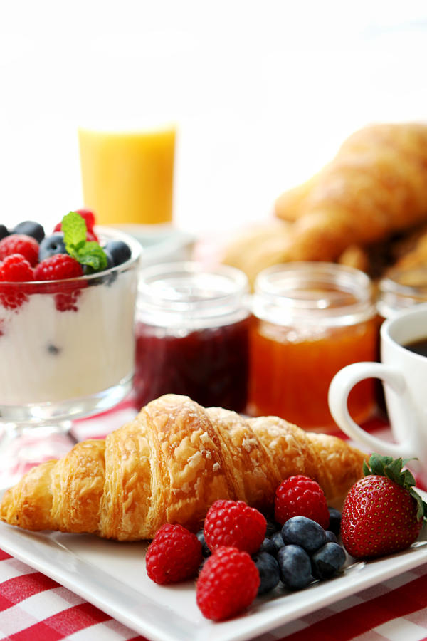 Breakfast of fruit, juice, yogurt, croissant and coffee Photograph by Kirin_photo