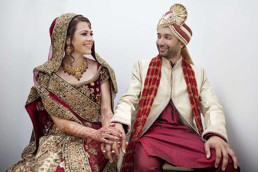 Bride and groom in traditional Indian wedding clothing Photograph by Blend Images - Kyle Monk