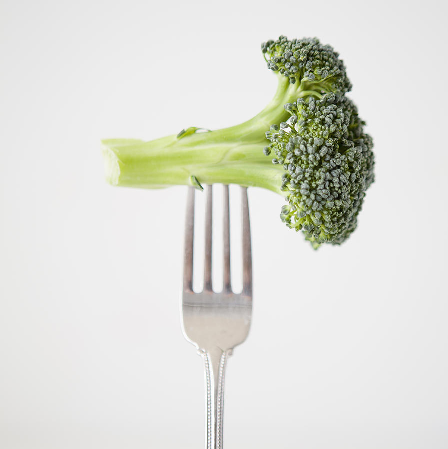 Broccoli on fork, studio shot Photograph by Jessica Peterson