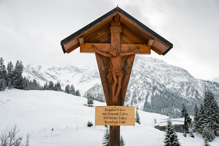 Brown wayside crucifix in the mountains in winter with snow Photograph by Matthias Hauser
