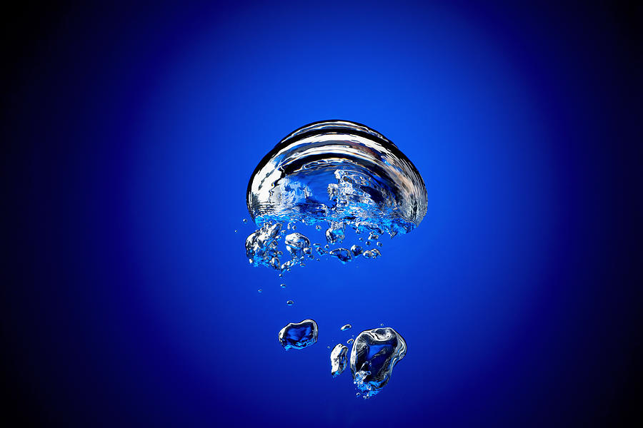 Bubbles in water, against blue background, (blurred motion) Photograph by Lew Robertson