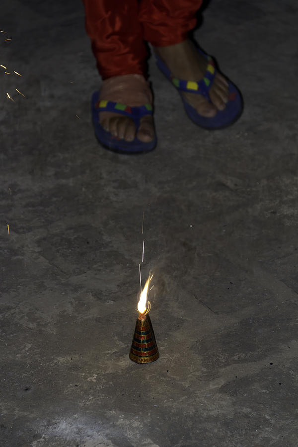 Burnt out firecracker at the feet of a lady Photograph by Ashish Agarwal