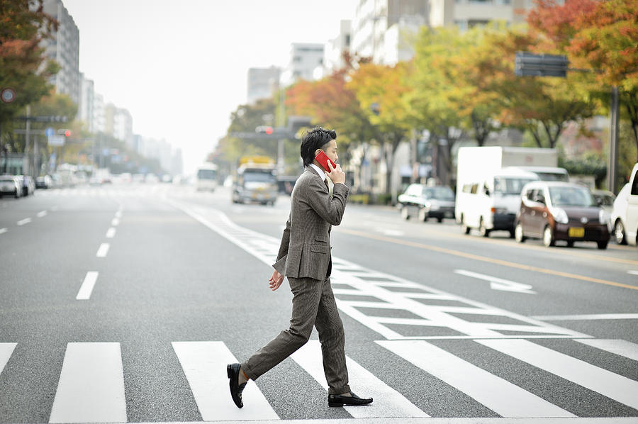 Business man using the smartphone in the city Photograph by Yagi Studio