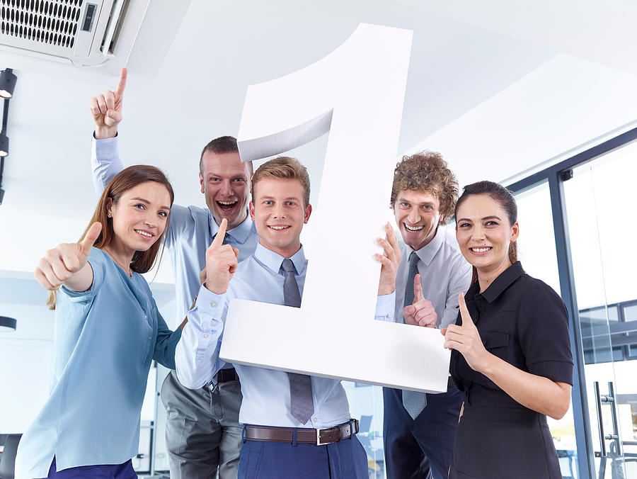 Business people holding large number 1 Photograph by Stockvisual