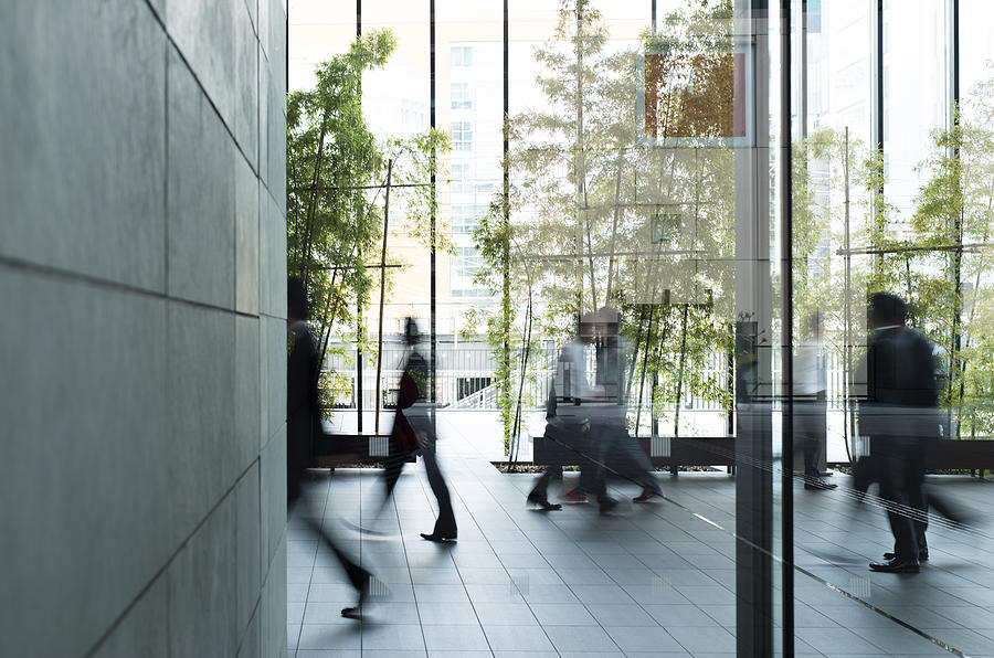 Business person walking in a urban building Photograph by Kokouu