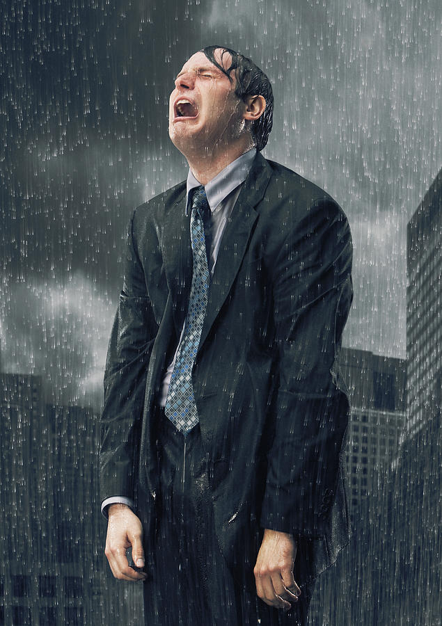 Businessman crying in rain Photograph by PM Images